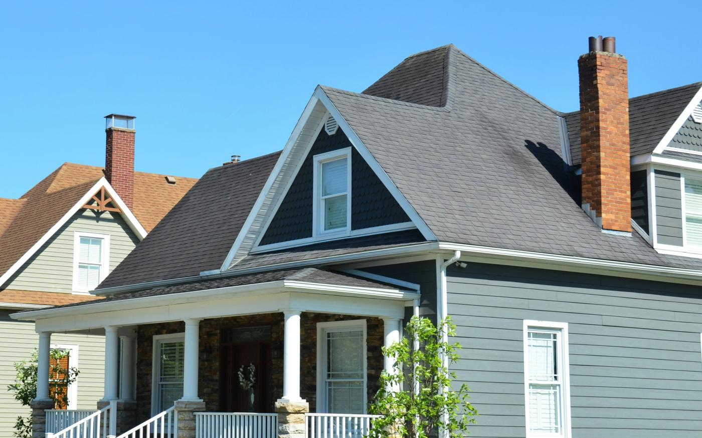 A blue house with a white porch and red chimney by Roger Starnes Sr courtesy of Unsplash.
