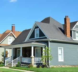 A blue house with a white porch and red chimney by Roger Starnes Sr courtesy of Unsplash.